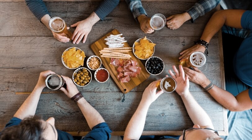 group of friends sitting around the table eating and drinking